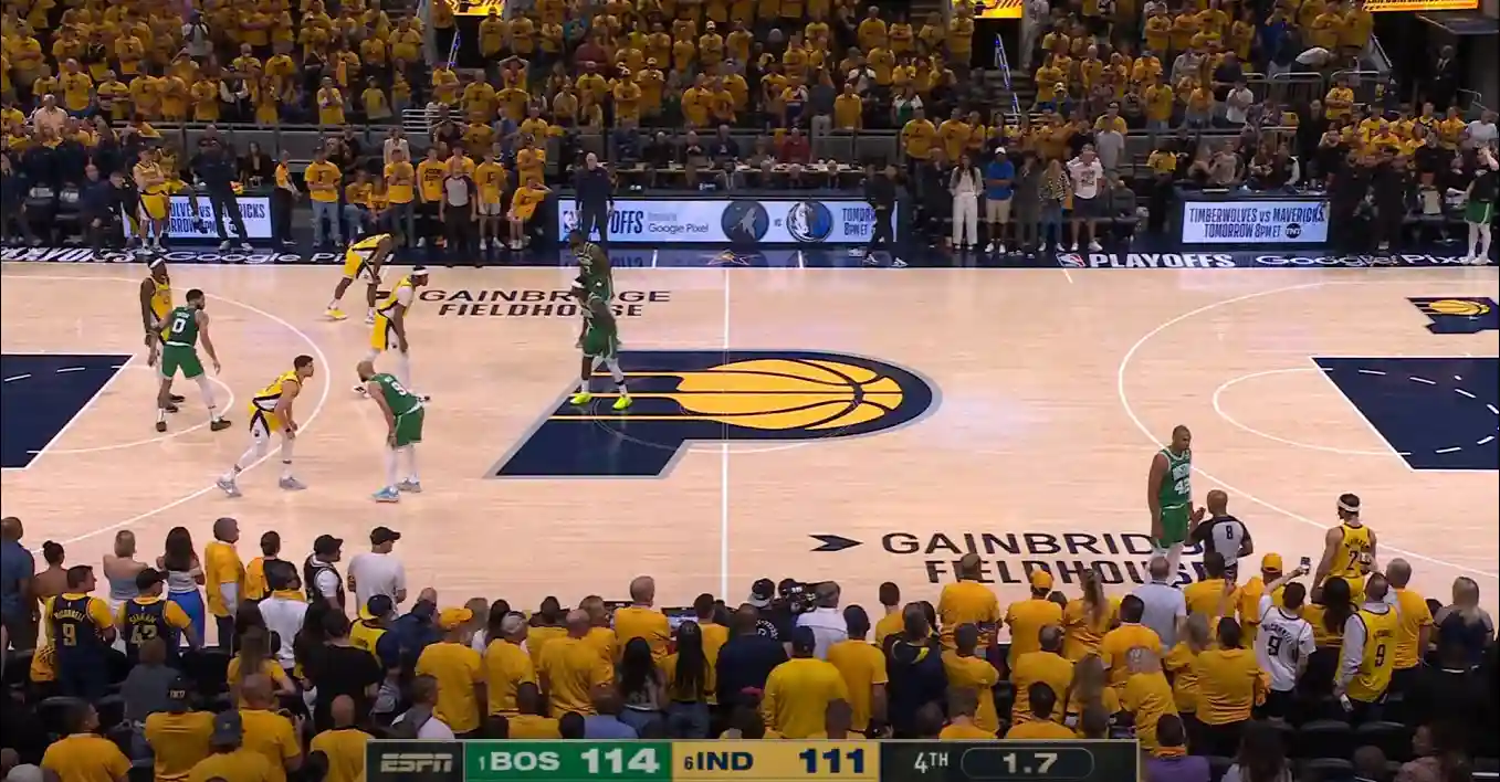 Basketball game with Boston 114 and Indiana 111, 1.7 seconds remaining in the fourth quarter at Gainbridge Fieldhouse. The crowd in yellow shirts watches intensely as the Boston Celtics and Indiana Pacers battle it out, evoking an Eastern Conference Finals atmosphere.