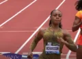Two athletes are running on a track. The athlete in the foreground, Sha'Carri Richardson, wears a green uniform with "RICHARDSON" on it. Competing in the renowned Prefontaine Classic, the athlete behind wears an orange uniform with "THOMPSON-HERAH" emblazoned across it.