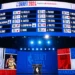 A large LED screen shows the order of NBA draft picks for 2024. Below the screen, a podium is set up under bright lights, with "DRAFT 2024" and NBA logos prominently displayed, making it the centerpiece for all 2024 NBA Draft news.