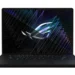 A black ASUS ROG Zephyrus G16 laptop displaying a vibrant geometric pattern with a logo in the center on its screen, perfect for performance reviews and benchmarks.