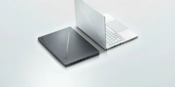 A closed, dark-colored laptop sits next to an open, light-colored laptop on a light gray surface. Both laptops have minimalistic designs, but the 2024 gaming laptop stands out with its sleek profile and advanced Dolby Atmos technology.