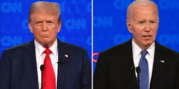 Two men are standing at podiums with microphones, facing forward, during a CNN 2024 presidential debate. The background features the CNN logo repeatedly, setting the stage for Biden vs Trump as they share debate highlights.