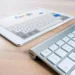A white tablet displaying the Google search page is placed on a wooden surface next to a slim, silver wireless keyboard, highlighting the seamless integration enabled by the strategic partnership between Google Cloud and Oracle Database.