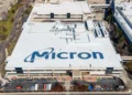 Aerial view of a large industrial building with "Micron" written on the roof, surrounded by parking lots and smaller structures, highlighting the scale of operations central to the Micron earnings report.