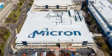 Aerial view of a large industrial building with "Micron" written on the roof, surrounded by parking lots and smaller structures, highlighting the scale of operations central to the Micron earnings report.