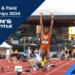 An athlete, Ackelia Smith, in mid-air during a long jump at the NCAA Track & Field Championships 2024, with "Women's X2 Jump Title" text on the image. Stadium and spectators in the background.