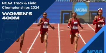 Four female athletes are sprinting down the track in the Women's 400m event at the NCAA Track & Field Championships 2024, with two runners from Arkansas setting an impressive pace and a potential collegiate record.