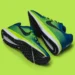 Image of a pair of blue and green athletic running shoes with black soles, placed on a bright green background, showcasing the innovative design that Nike CEO John Donahoe praised for its blend of style and performance.