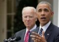 Barack Obama and Joe Biden in formal attire stand behind a podium outdoors. One is speaking into the microphone, while the other is looking on, reminiscent of an Obama-Biden debate moment.