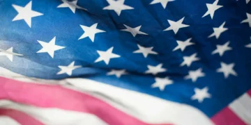 Close-up of the American flag showing the blue field with white stars and a portion of the red and white stripes, symbolizing unity as pivotal strategic initiatives take shape.
