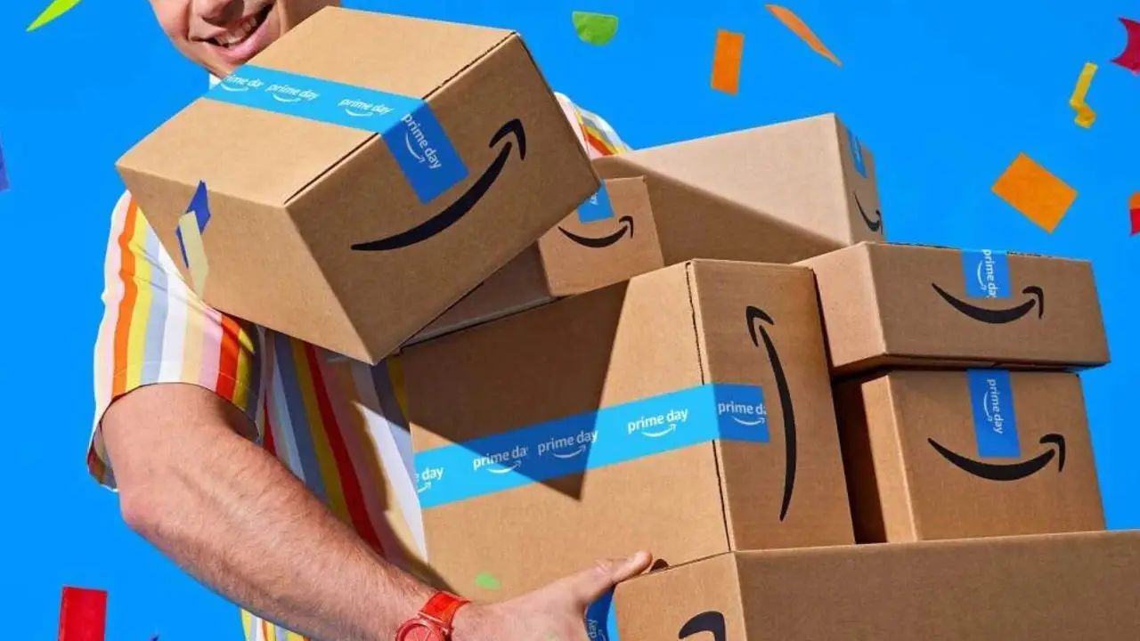 A person wearing a striped shirt carries several Amazon boxes with Prime Day tape against a blue background with colorful confetti, showcasing unmissable deals.