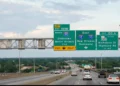 Multiple-lane highway with green overhead signs indicating exits 155B for I-110 North, and 155A for I-10 East towards New Orleans/Hammond, and LA-30 to Nicholson Dr/Highland Rd with cars driving below on a Louisiana highway.