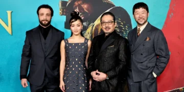 Four FX series Shogun cast members stand side by side in formal attire against a blue backdrop with a large image of a historical figure in the background, celebrating their Emmy nominations for the 2024 Emmys.