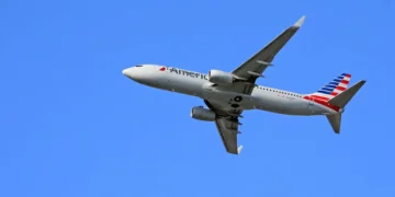 A United Airlines Boeing 757-200 shown in-flight against a clear blue sky, soaring smoothly on its route from Los Angeles to Denver.