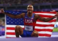 Quincy Hall Olympic Gold-medalist 400m holding American flag