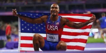Quincy Hall Olympic Gold-medalist 400m holding American flag