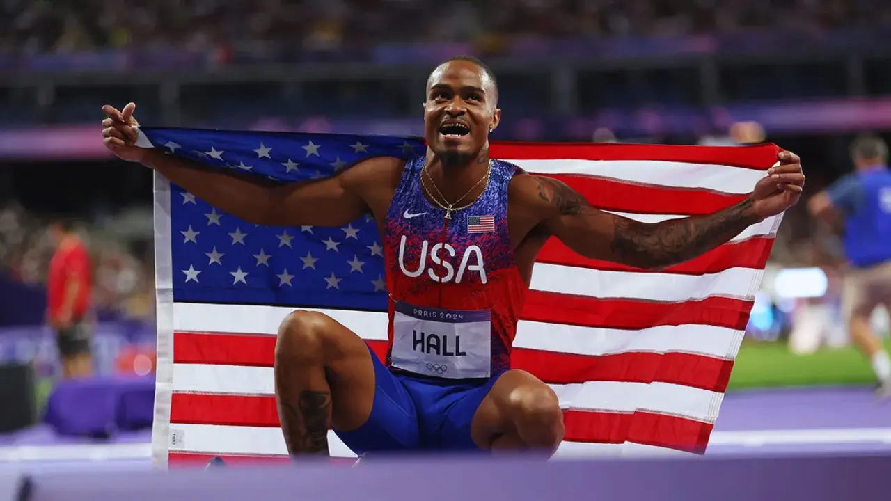 Quincy Hall Olympic Gold-medalist 400m holding American flag
