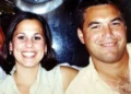 A man and woman smile at the camera while sitting closely together, their expressions masking a tragic past linked to the notorious 2002 murder involving Scott Peterson’s wife and unborn child. The background is slightly blurred.