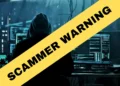 A person in a dark room sits at a computer with multiple screens displaying data. Overlaid in yellow text reads "SCAMMER WARNING," as the Kenosha sheriff warns of scammers targeting residents.