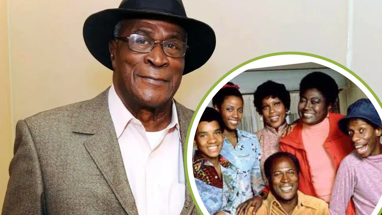 Older man in a hat and suit stands smiling. Inset shows John Amos, the beloved actor, posing and smiling with a group of six people.