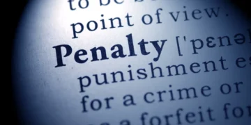 A close-up of a dictionary page shows the word "Penalty" in bold, with partial definition and phonetic spelling visible—an important term for any Danbury homeowner managing property cleanup.