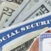 A Social Security card overlaid on various US dollar bills symbolizes the connection between beneficiaries and their upcoming payment schedule.